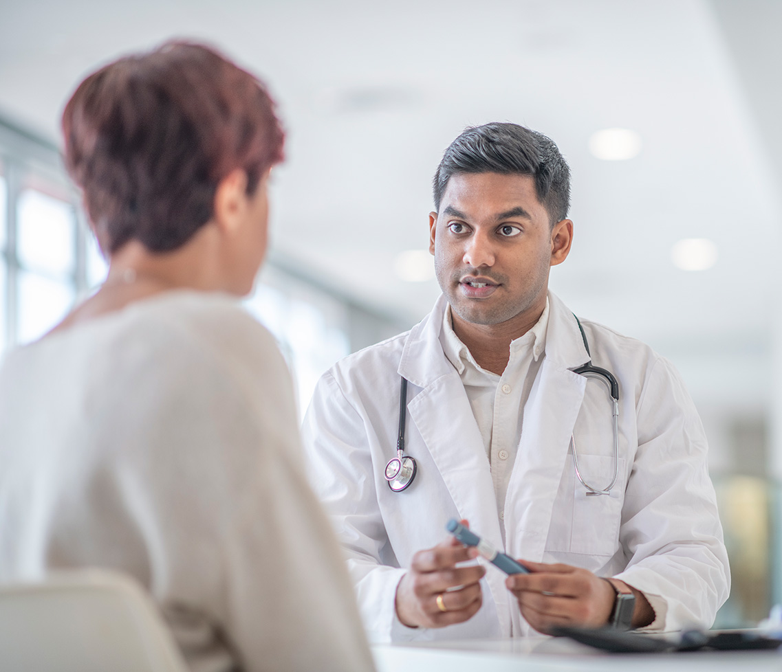 Clinician sat across desk from patient