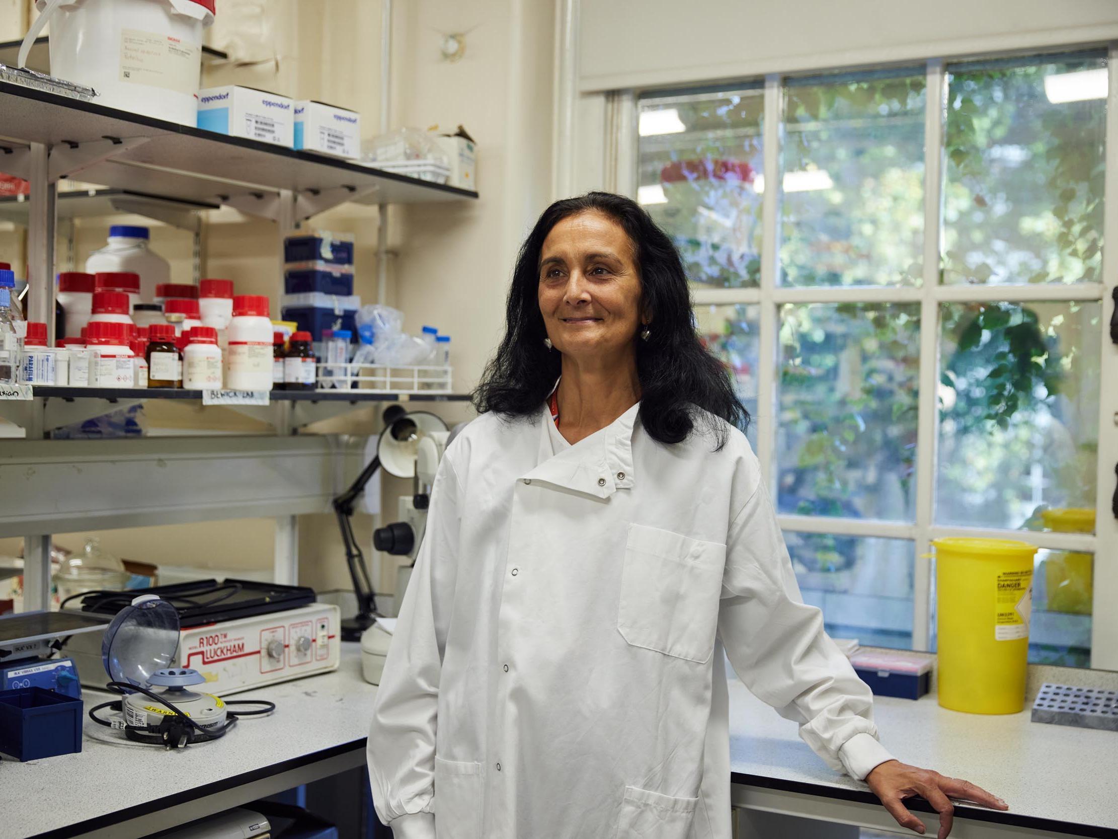 Prof Shanta Persuad standing in the lab wearing a white lab coat