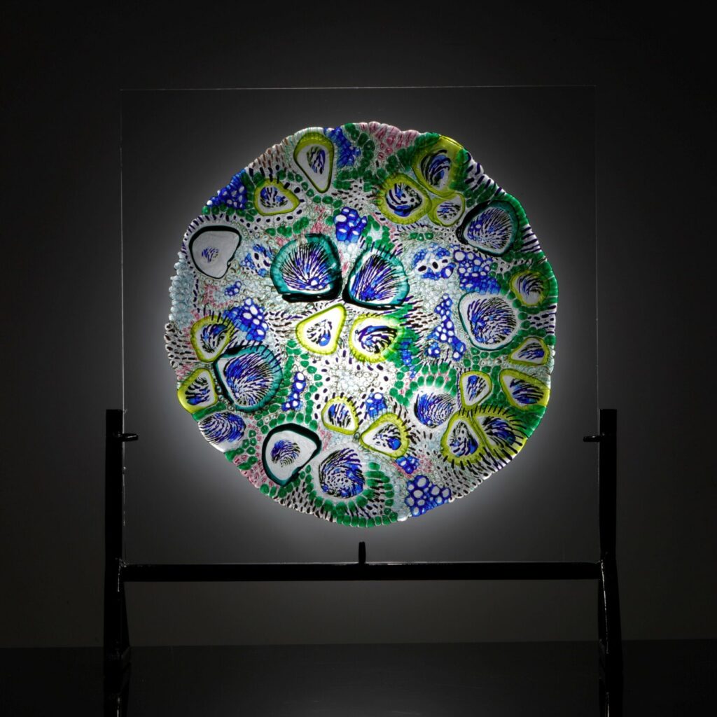 Amelia Skachill Burke's glass art - a round plate with swirling blue and green shapes representing beta cells